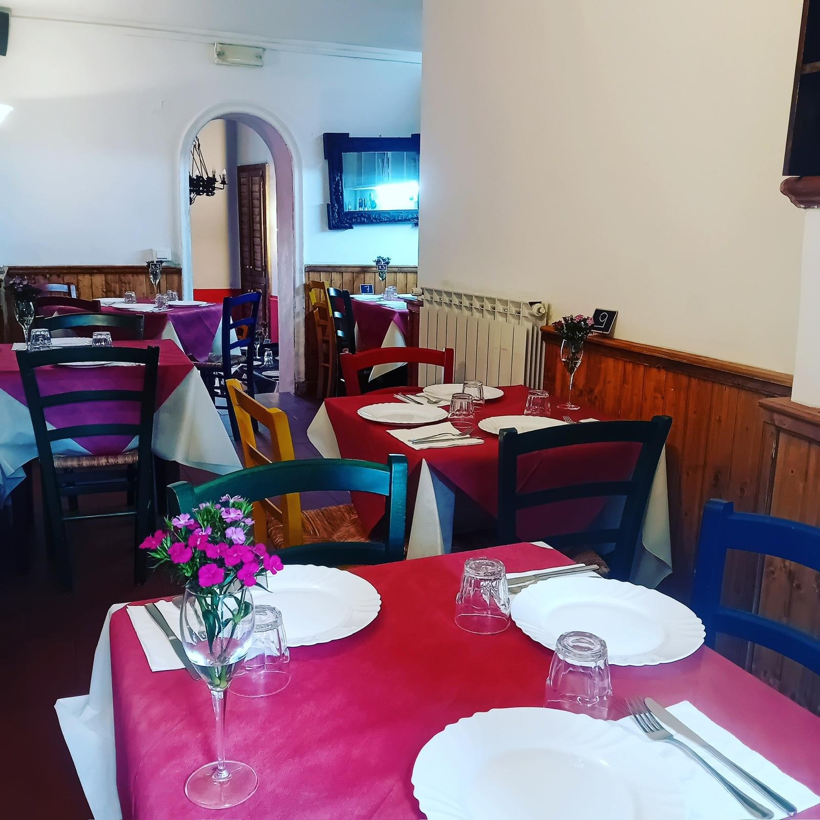 Sala interna dell'osteria con tavoli apparecchiati