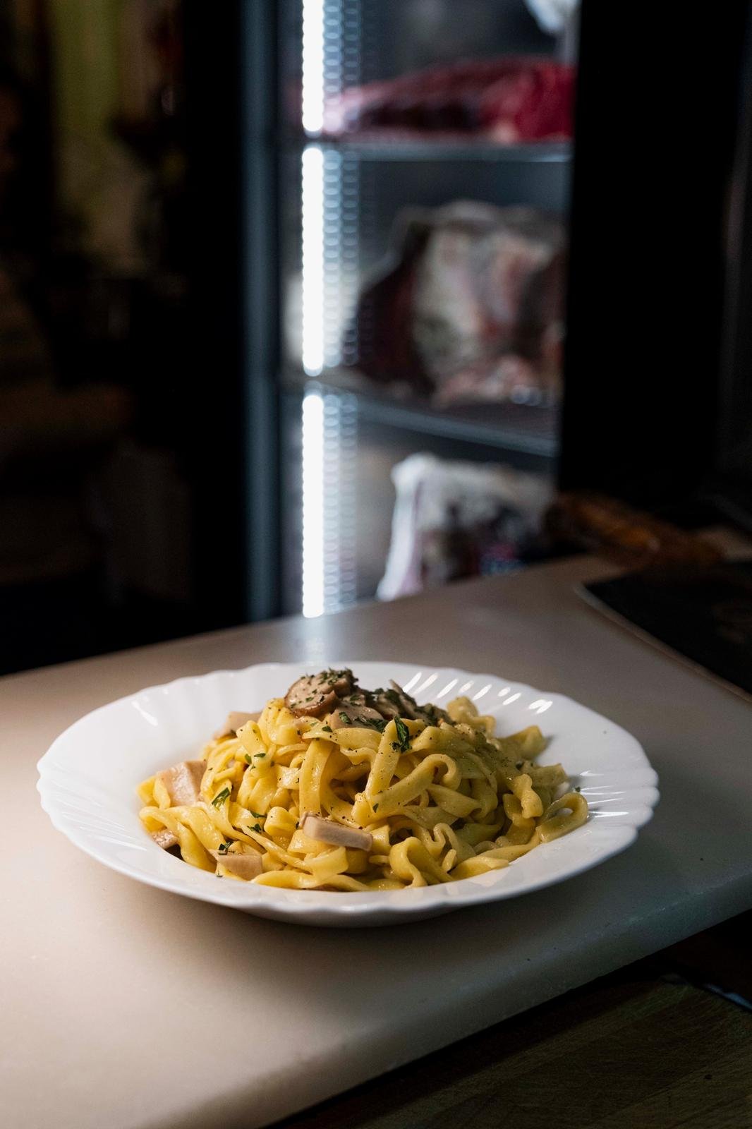 Piatto di pasta fresca con funghi ed erbe aromatiche